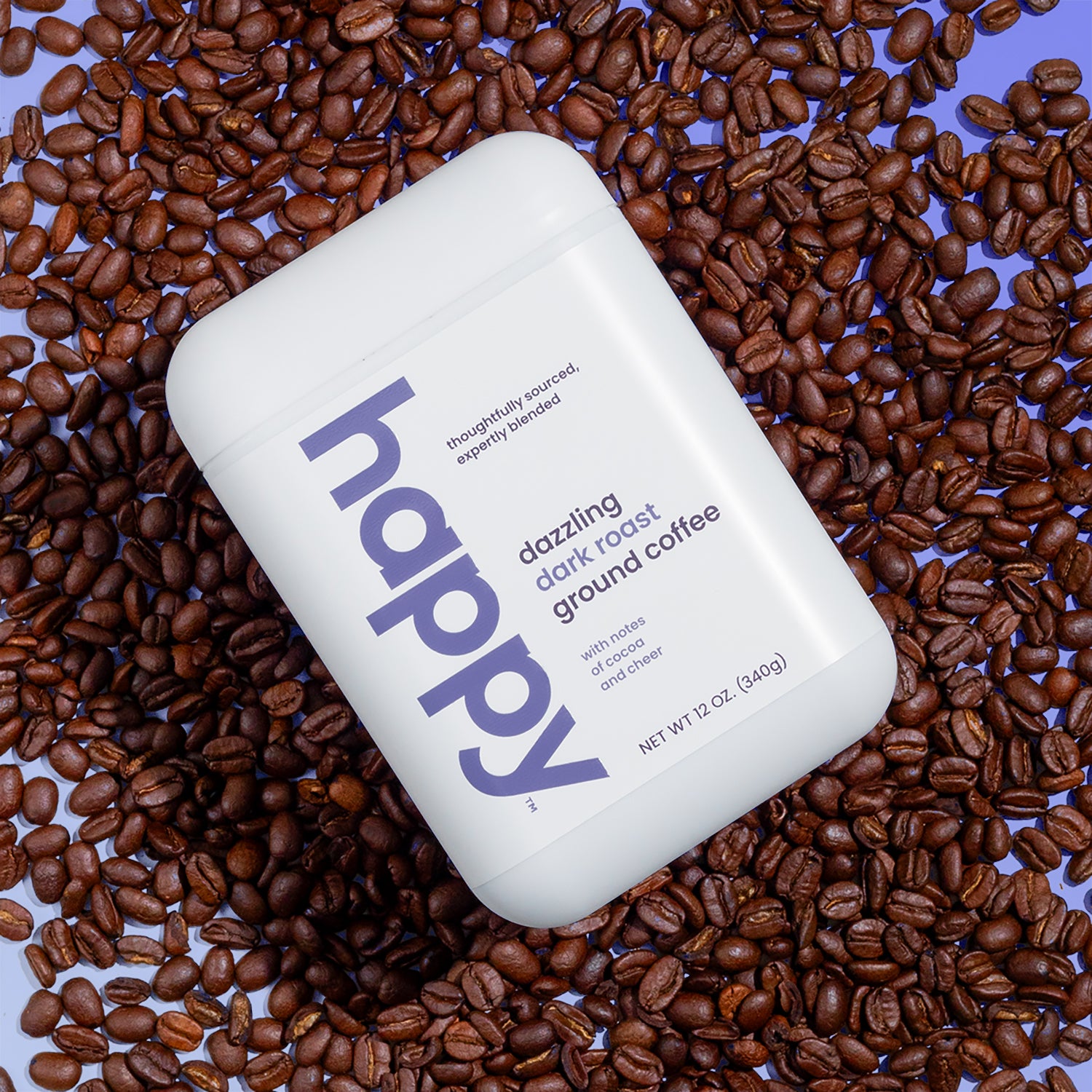 A container of dazzling dark roast ground coffee resting on a bed of coffee beans